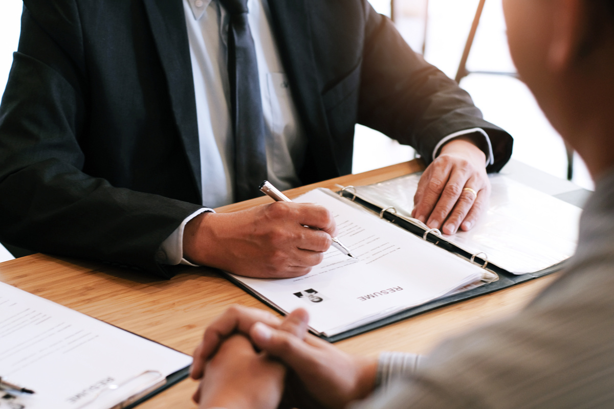 Examiner reading a resume during job interview at office Busines